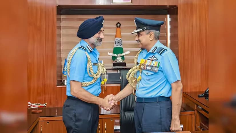 दो भारतीय वायु सेना अधिकारी एक कार्यालय में हाथ मिला रहे हैं।