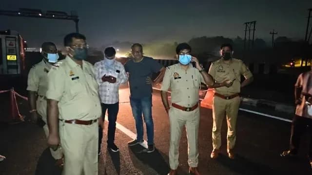 रात में सड़क पर खड़े पुलिस अधिकारी और नागरिक।