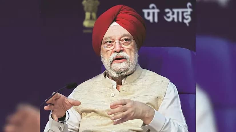 एक सिख व्यक्ति लाल पगड़ी और बेज रंग की जैकेट पहने हुए बोल रहा है।