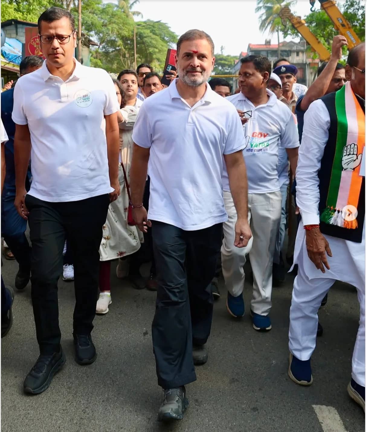 राहुल गांधी और अन्य लोग सड़क पर चल रहे हैं, उनके माथे पर तिलक लगा हुआ है।