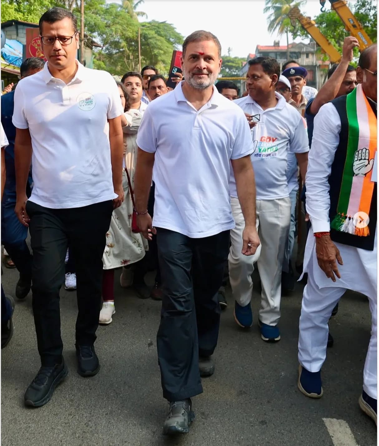 राहुल गांधी और अन्य लोग सड़क पर चल रहे हैं, उनके माथे पर तिलक लगा हुआ है।