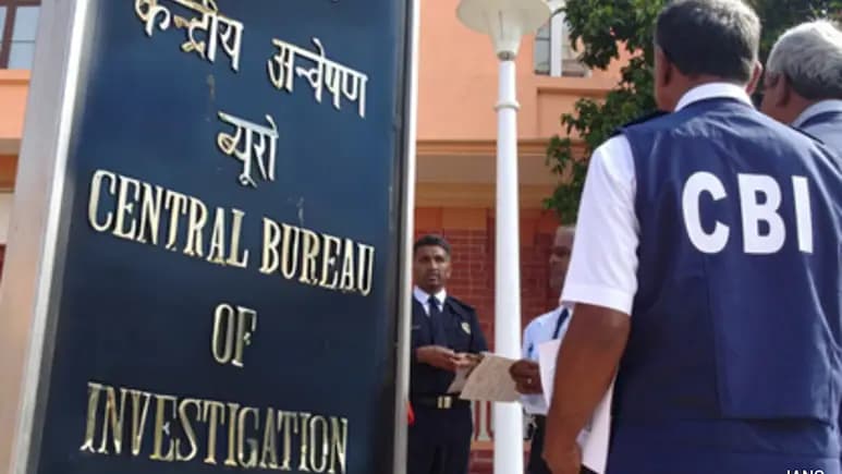 सीबीआई के अधिकारी एक बोर्ड के पास खड़े हैं जिस पर "केंद्रीय अन्वेषण ब्यूरो" लिखा है।