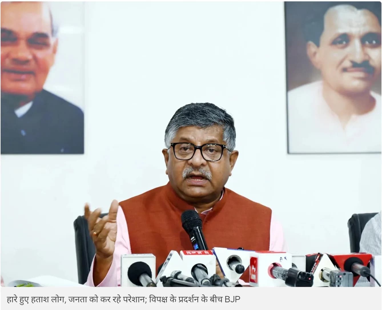 एक व्यक्ति पत्रकारों से बात कर रहा है।