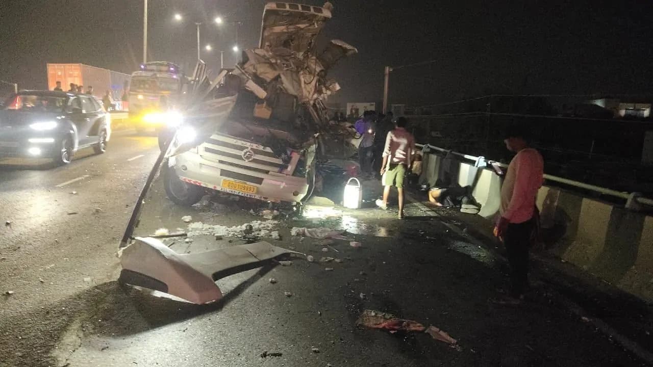 रात में एक सड़क दुर्घटना, जिसमें एक ट्रक और एक कार बुरी तरह क्षतिग्रस्त हो गए हैं, और लोग आसपास खड़े हैं।