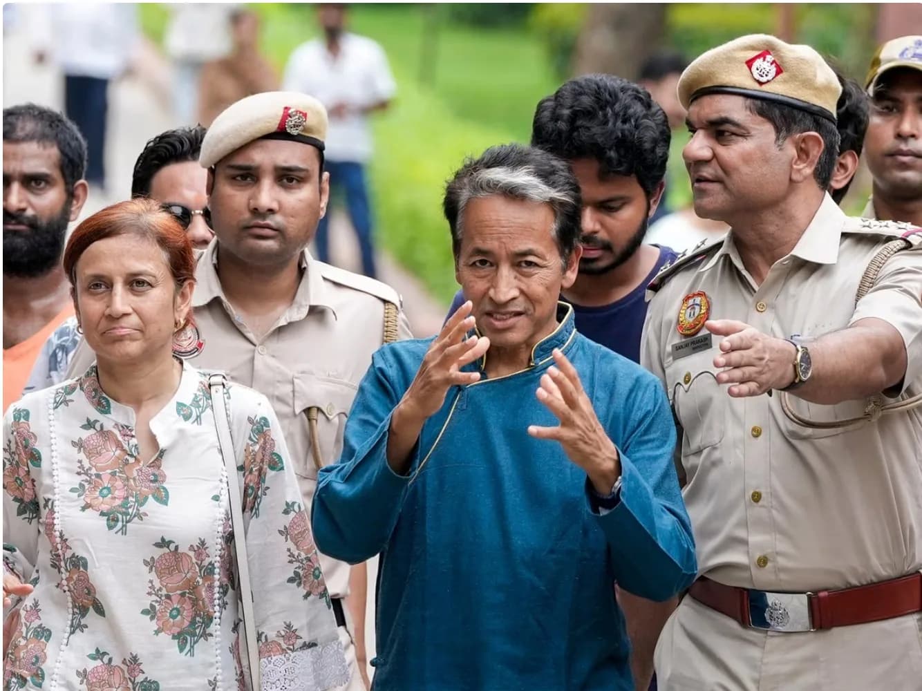 एक महिला, एक व्यक्ति और पुलिसकर्मी एक साथ चल रहे हैं।
